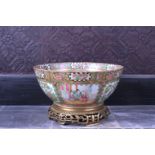 A Chinese Canton famille rose bowl with palace scenes and birds and butterflies among blossoming bra