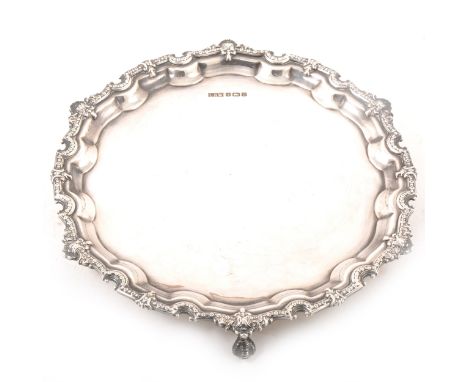 A circular silver salver by Laurence R Watson &amp; Co, Sheffield 1978, plain polished base with fine flower head and shell b