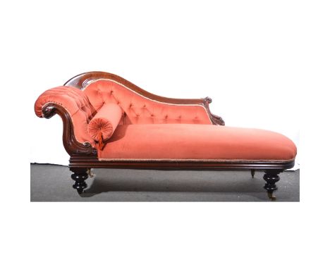 A Victorian mahogany chaise-longue, upholstered in salmon coloured dralon, scrolled moulded back with button upholstery, scro