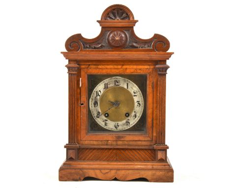 A Victorian walnut bracket clock, shaped and carved pediment, the dial flanked by fluted columns, the movement striking on tw