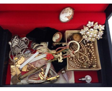 A black jewellery box containing costume jewellery & other items to include cameo brooch & choker, early plastic ring of char