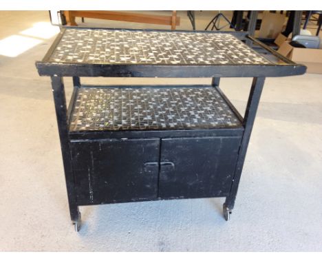 A retro black painted wooden hostess trolley with tiled shelf & top.  