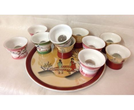 A set of 5 Saki cups on tray with another set of 6, all with glass domed bottom revealing images of naked figures.  