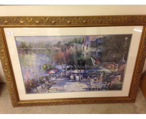 A large framed & glazed print of a riverside café scene. 73 x 104cm.  