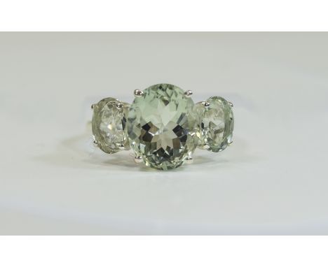 Green Amethyst Three Stone Ring, a 5ct oval cut green amethyst flanked by two further green amethysts of 1ct each, set in a c