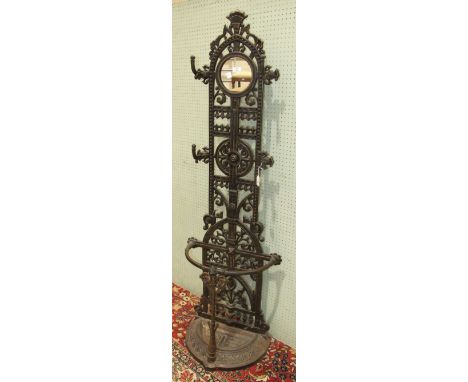 A reproduction cast iron hall stand with four coat pegs, small central mirror and bow-fronted stick stand, 170cm high, 51cm w