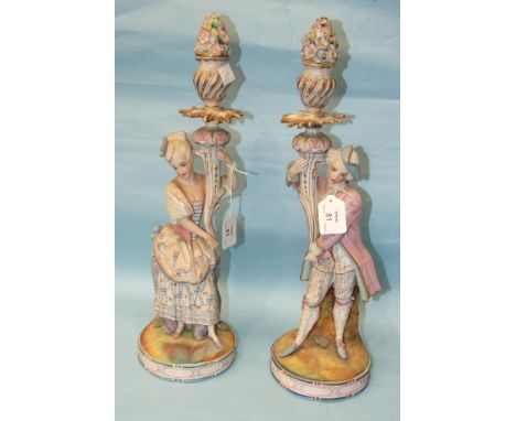A pair of late-19th century Continental painted biscuit ceramic figural candlesticks, on circular bases, 46cm high, (2).