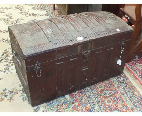 An early-20th century wood-bound metal-covered cabin trunk with domed hinged lid and leather carrying handles, 82cm wide, pai