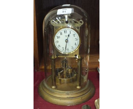 A brass anniversary clock by Badische Uhrenfabrik, under glass dome, 28cm high overall.
