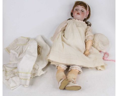 A vintage German Handwerck Halbig bisque headed doll having rolling eyes and four upper teeth, approx length 49cm