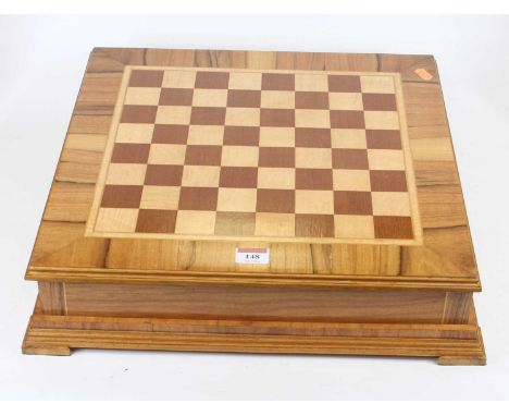 A walnut and maple veneered chessboard, the board lifting to reveal storage beneath, 42 x 42cm 