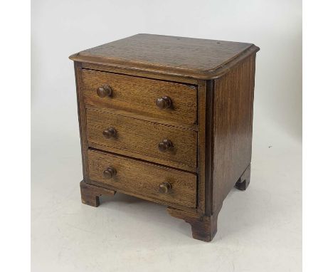A Victorian style oak apprentice round corner chest, containing three long drawers, on bracket feet, w.26cm 
