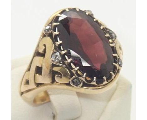 Vintage heavy gauge yellow metal presumed 18ct gold gents ring set with a large oval garnet and six diamonds, having celtic d