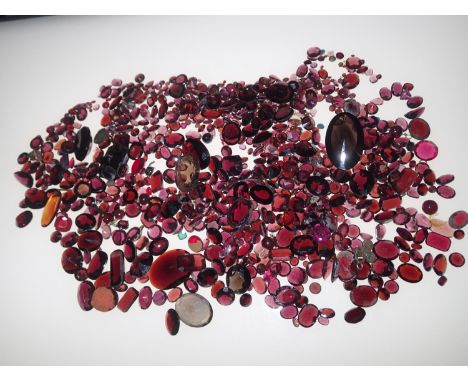 Loose gemstones: Large amount of garnets and garnet coloured stones, largest stone weighing 24.4cts, 25.7mm x 15mm gross weig