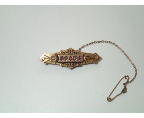 Antique 9ct gold mourning bar brooch set with red stones and seed pearls, the reverse having a small circular glass display p