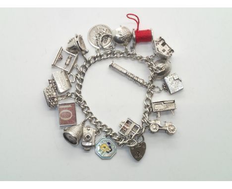 Heavy vintage silver charm bracelet with 19 charms with many Nuvo examples, including rare cotton reel, book cupboard and ste