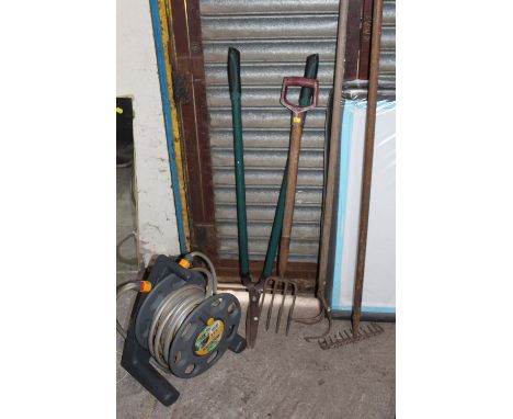 A HOSE REEL TOGETHER WITH FOUR GARDEN TOOLS