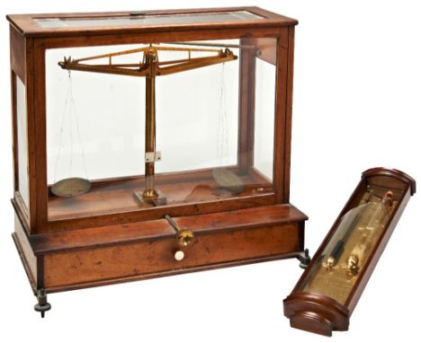 A BRASS SCIENTIFIC BALANCE IN A MAHOGANY GLAZED CASE,&nbsp;early 20th century, over a lower drawer with a selection of cased 