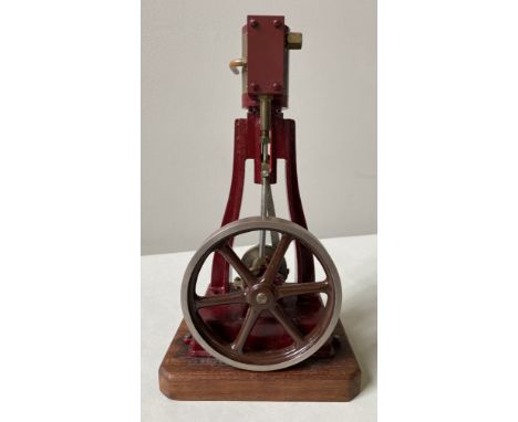 AN ENGINEERED VERTICAL STEAM ENGINE&nbsp;with maroon livery and a small vertical steam piston with solid pulley flywheel. 29 