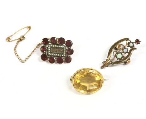 A gold single stone oval cut citrine brooch, (tested as 9ct gold) 4.27g, a gold Georgian garnet and seed pearl memorial brooc