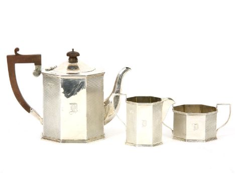 A silver octagonal three piece tea set to, include a teapot with hardwood handle and finial by Wilmot Manufacturing Co, Birmi