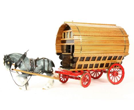 A model of a Romany caravan and horse, with painted wooden finish and ceramic shire horse, height 45cm, total length 70cm.