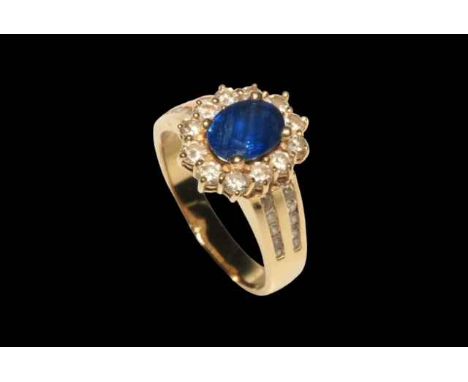 Sapphire and diamond 18 carat gold cluster ring, having approximately 1.5 carat oval sapphire bordered with twelve diamonds a