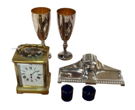 French gilt brass carriage clock, Arts &amp; Crafts inkstand, pair goblets and two blue glass liners.