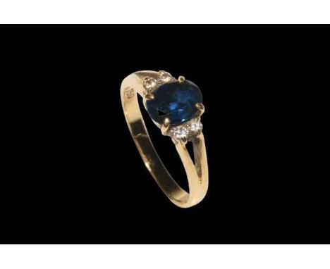 Sapphire and diamond 18 carat gold ring, having approximately 1.5 carat oval sapphire flanked by four brilliants, size P.