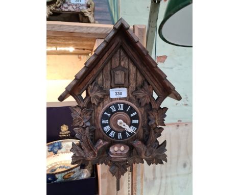 A carved wood cuckoo clock with pendulum and weights.All parts appear to be present but the clock has not been tested and is 