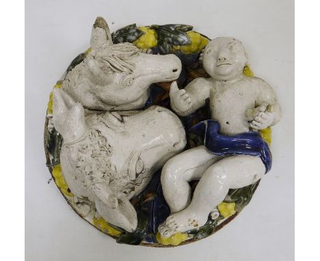 Continental pottery plaque, 20th century, in the Della Robbia-style, applied with a scantily draped figure, a bull's head and