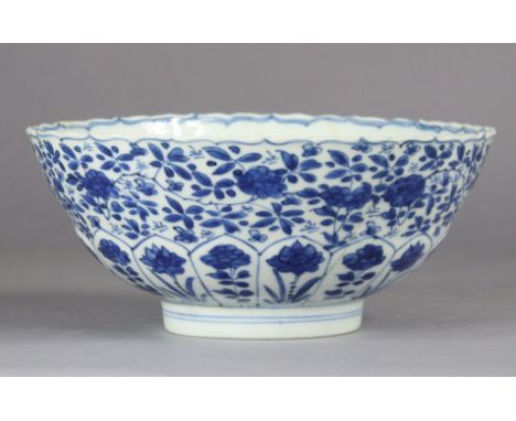 A Chinese blue &amp; white porcelain moulded ‘lotus’ bowl, painted with trailing flowers above a lobed petal border, on short
