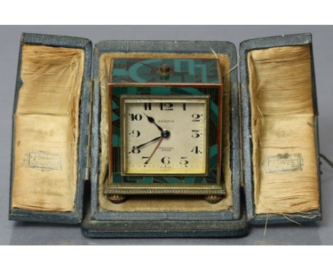An Art Deco Zenith travelling alarm clock in gilt brass rectangular case with enamelled geometric designs, the silvered dial 
