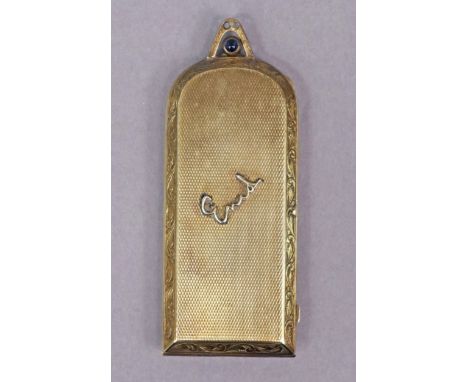 A continental silver-gilt engine-turned compact of narrow oblong form with rounded top set simulated sapphire to the push cla