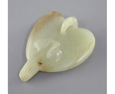 A Chinese yellow and russet jade carving of a falcon, Eastern Zhou dynasty or later, the stylised bird carved with scrolls an