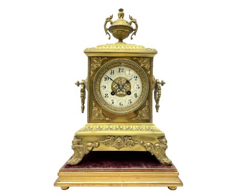 French gilt metal mantle clock c1900, the domed case surmounted by an urn with rococo swags, with circular side handles on a 