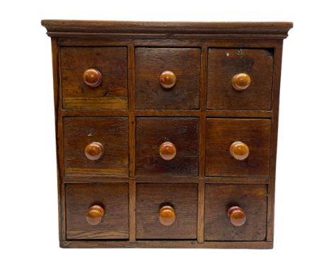 19th century oak spice rack, with moulded cornice over nine small drawers, each with turned handles, H43cm W45cm D25cmDimensi