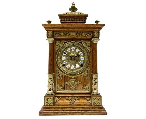 Late 19th century American mantle clock in a light oak case, raised pediment with a recessed balustrade frieze, pierced brass