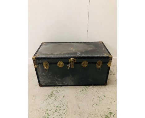 A Large metal travel trunk with decorative brass trimmings and leather handles (H50cm D50cm W103cm)