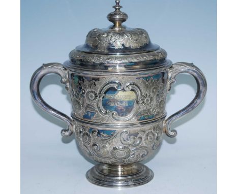 A large Victorian silver plated trophy cup and cover, the ogee domed cover with squat circular finial repousse decorated with