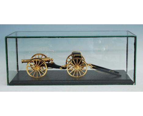 A lacquered brass scale model of a Napoleonic cannon and carriage, mounted on an ebonised plinth under a glass case, w. 58, d