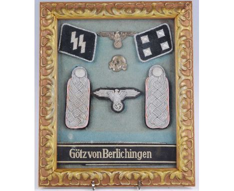 A framed display of items relating to The 17th SS Panzergrenadier Division, to include Totenkopf, epaulettes, SS collar badge