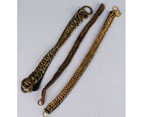A British Army leather backed chin strap with brass scales, 35cm, together with two others. (3)