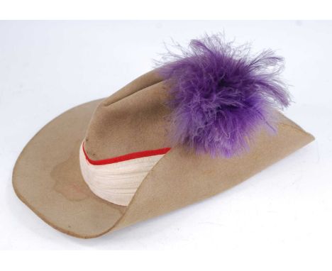 A WW II British Army bush slouch hat, in khaki having a folded rim to the left hand side with purple plume and red trimmed pa