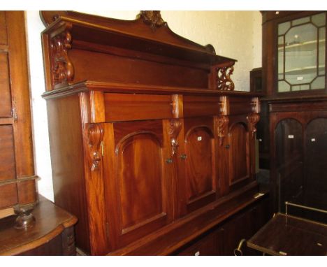 Reproduction mahogany chiffonier, the shelf back with carved surmount above three drawers and three dome topped panelled door