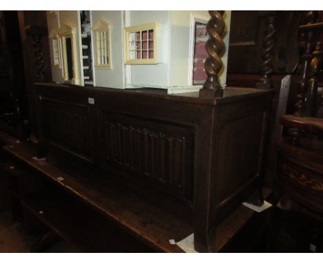 Early 20th Century oak monks bench with a fold-over top above barley twist uprights and a linen fold carved box base