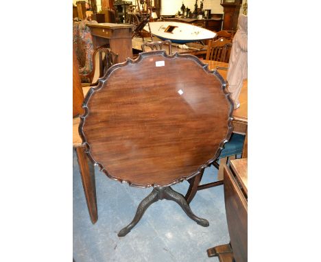 19th Century mahogany pedestal table in George III style, the shaped dish top above a carved baluster column and tripod base 