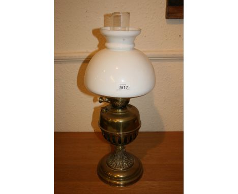 Brass oil lamp with a white opaque cut glass shade and a clear glass chimney