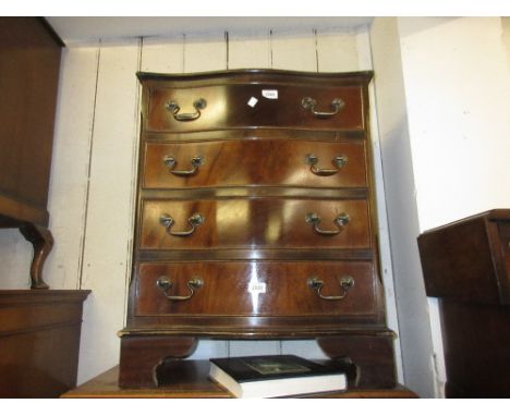 Small reproduction mahogany and line inlaid serpentine fronted chest of four drawers on bracket feet