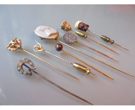 Two unusual mask head stick pins, a lava cameo stick pin, a Turk's head stick pin and four various others